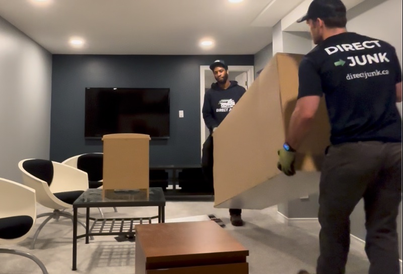 Crew carrying furniture through a basement