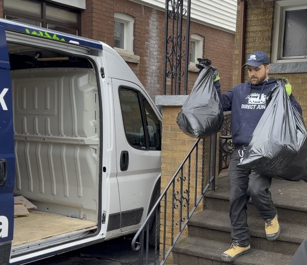 Crew member carrying bagged items from a home