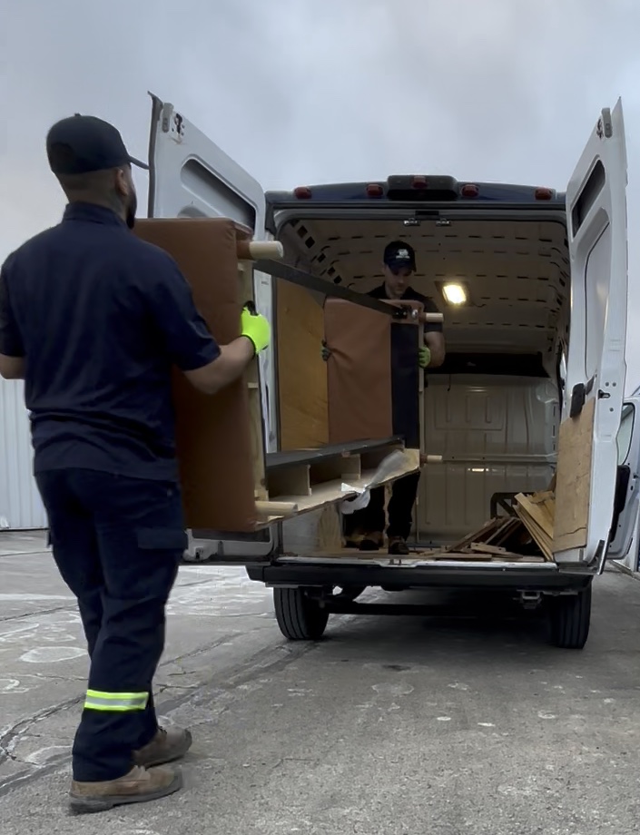 Direct Junk team loading heavy furniture into junk removal truck